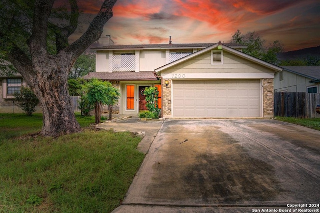 view of front of property with a garage and a lawn