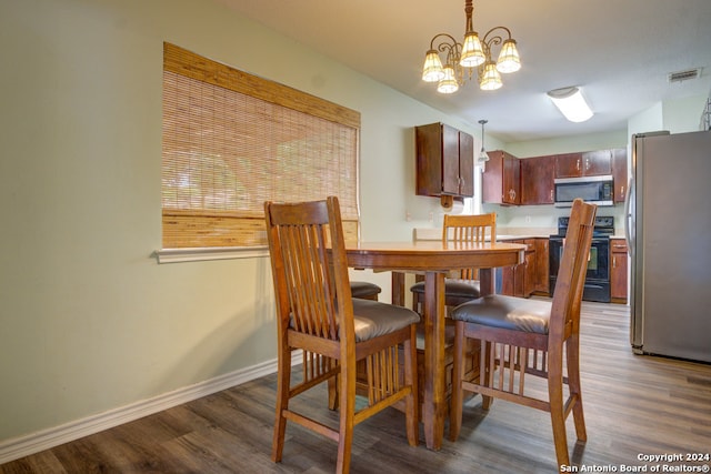 dining area with dark hardwood / wood-style flooring and a chandelier