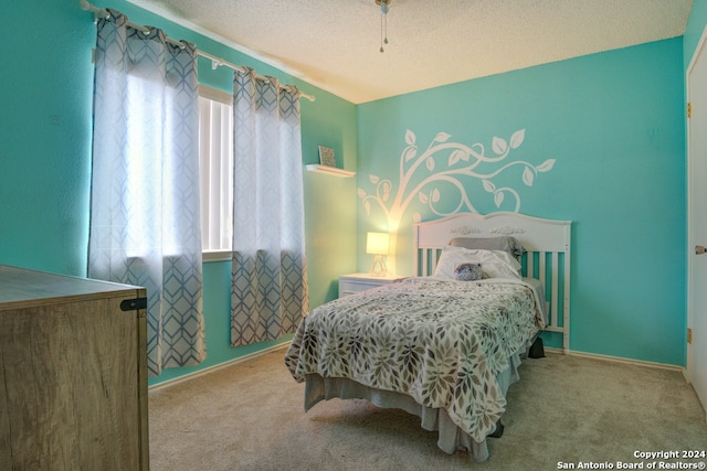 carpeted bedroom with multiple windows and a textured ceiling