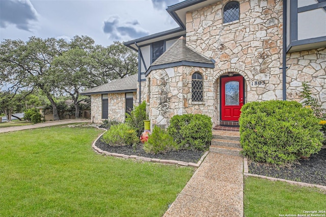 property entrance with a lawn