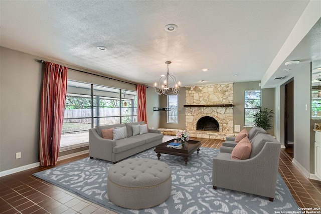 tiled living room featuring a fireplace, a chandelier, and a textured ceiling