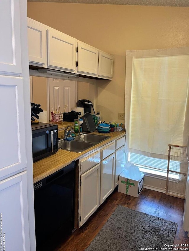 kitchen featuring sink, dark hardwood / wood-style floors, black appliances, and white cabinetry