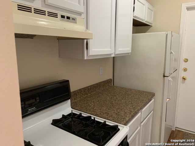 kitchen with white cabinetry and white range