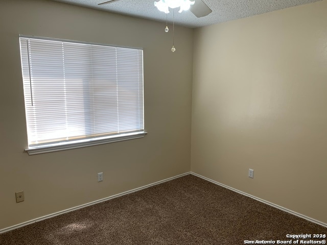 spare room with carpet floors, a textured ceiling, and ceiling fan