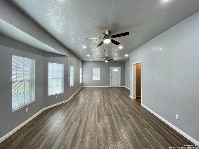 unfurnished living room featuring ceiling fan, dark hardwood / wood-style floors, and a textured ceiling