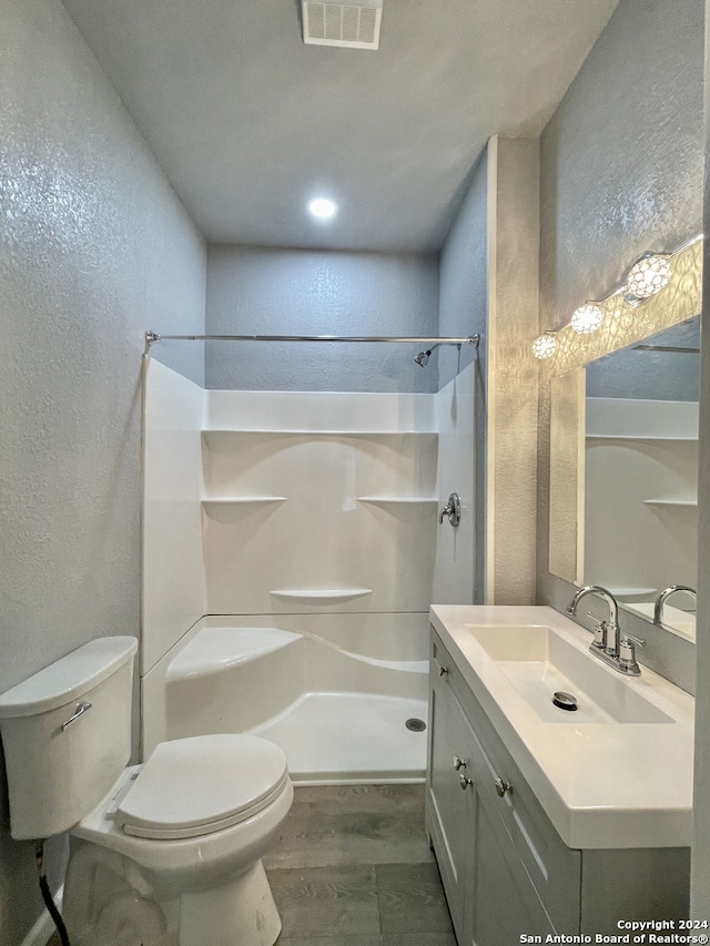 bathroom with vanity, hardwood / wood-style flooring, and toilet