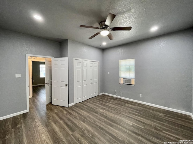 unfurnished bedroom with ceiling fan, a closet, dark wood-type flooring, and a textured ceiling