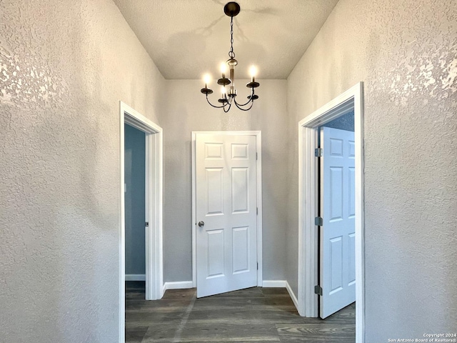 hallway featuring a chandelier and dark hardwood / wood-style floors