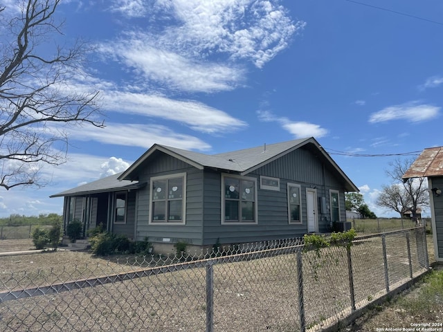 view of front of house with a fenced front yard and central AC unit