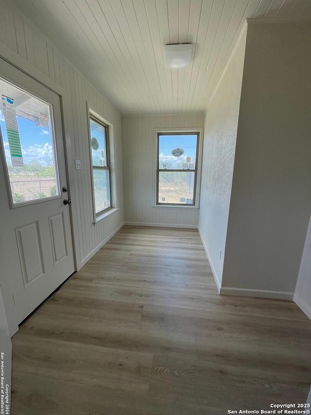 interior space featuring light wood-style flooring, wooden ceiling, and baseboards