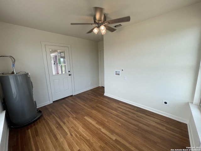 empty room featuring visible vents, a ceiling fan, electric water heater, wood finished floors, and baseboards