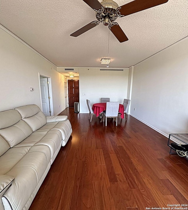 living room with ceiling fan, dark wood-type flooring, and a textured ceiling