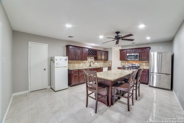 dining area with light tile patterned flooring, sink, and ceiling fan