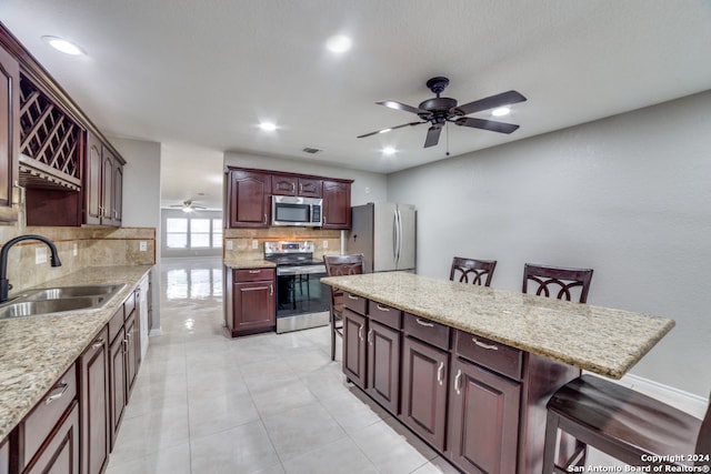 kitchen with sink, ceiling fan, tasteful backsplash, and stainless steel appliances