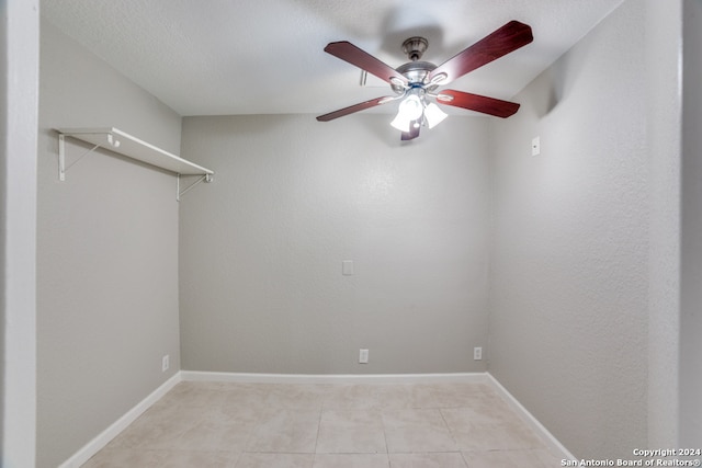 tiled empty room featuring ceiling fan