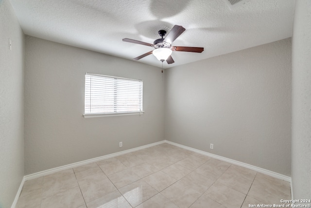 unfurnished room featuring light tile patterned flooring, a textured ceiling, and ceiling fan