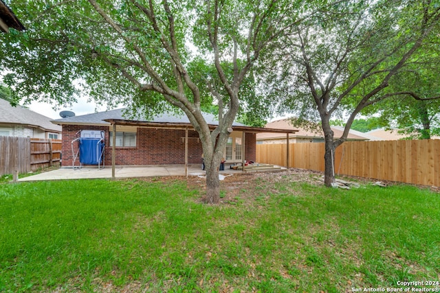 back of house with a patio and a lawn