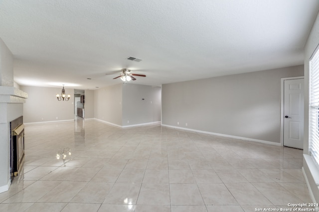 unfurnished living room with a textured ceiling, ceiling fan with notable chandelier, and light tile patterned floors