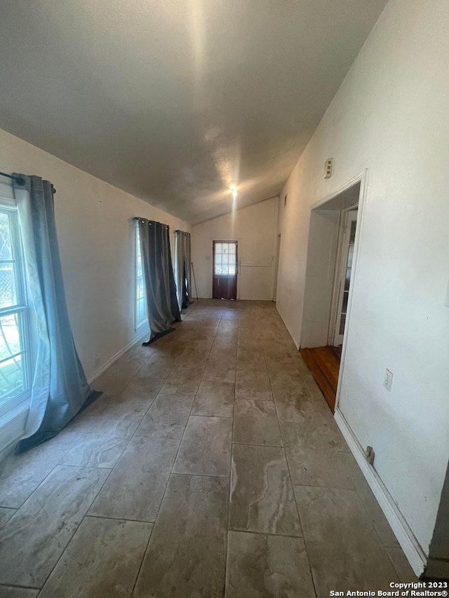 unfurnished room with lofted ceiling