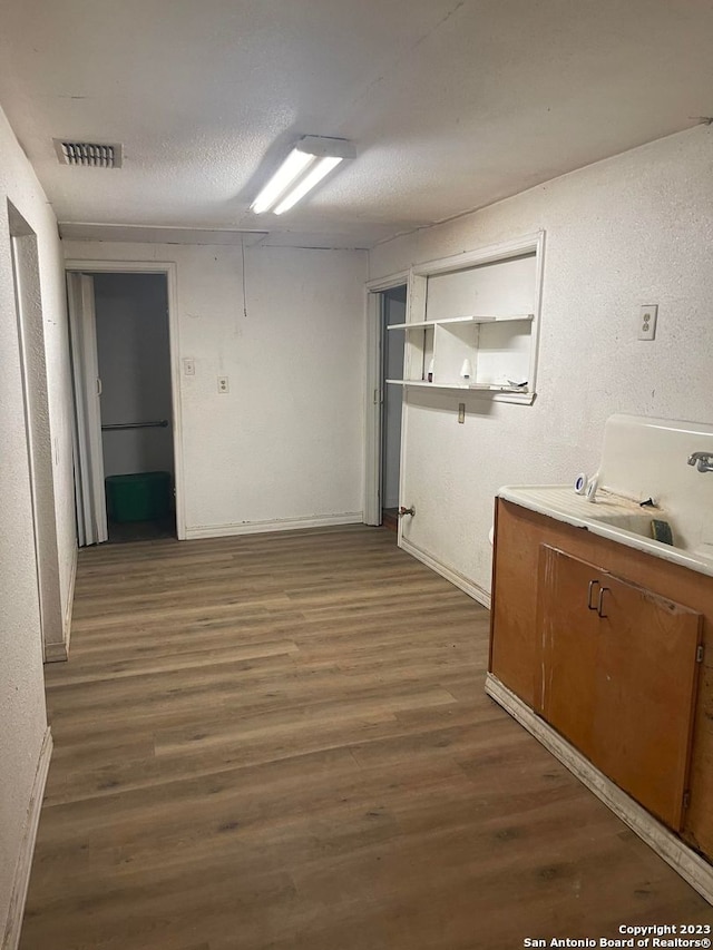 interior space featuring dark hardwood / wood-style floors, sink, and a textured ceiling