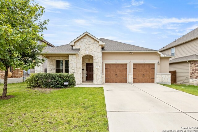 view of front of home with a front yard and a garage