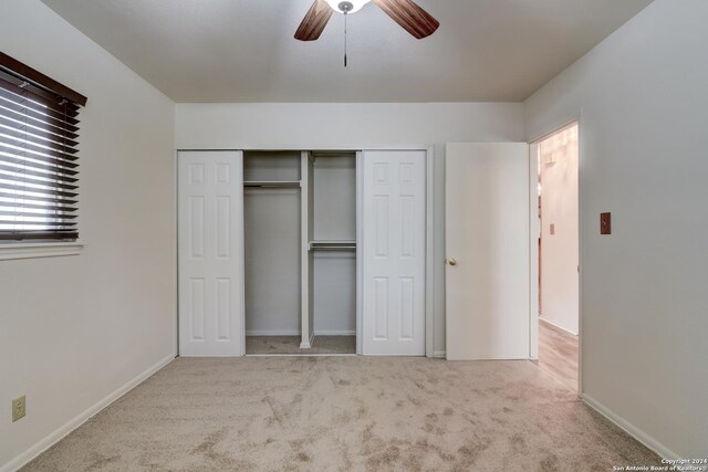 unfurnished bedroom featuring light carpet, ceiling fan, and a closet