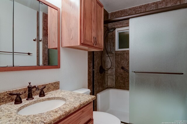 full bathroom with vanity, tiled shower / bath combo, and toilet