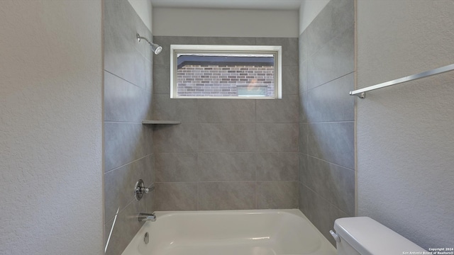 bathroom with tiled shower / bath and toilet