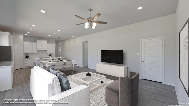 living room featuring ceiling fan and wood-type flooring