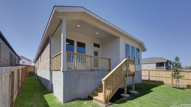 back of house with a yard and central AC unit