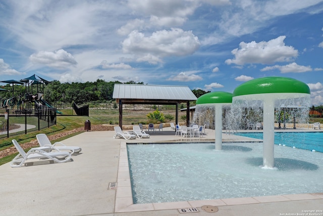 view of pool featuring a playground, a gazebo, pool water feature, and a patio