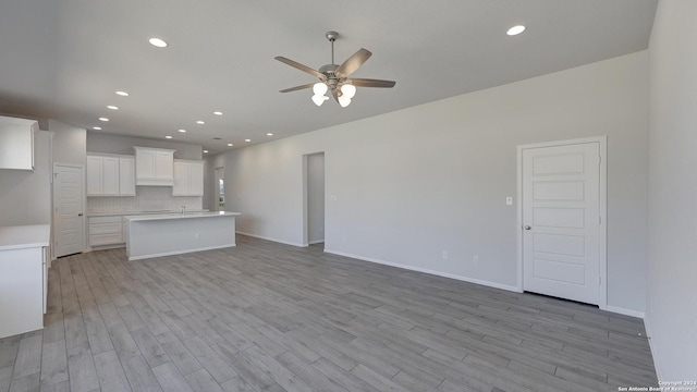 unfurnished living room with ceiling fan and light hardwood / wood-style floors