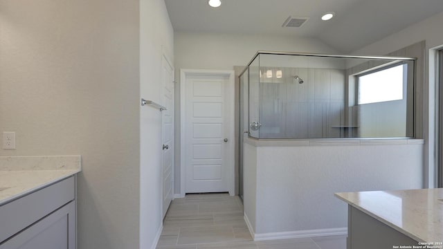 bathroom featuring vanity, a shower with door, and lofted ceiling