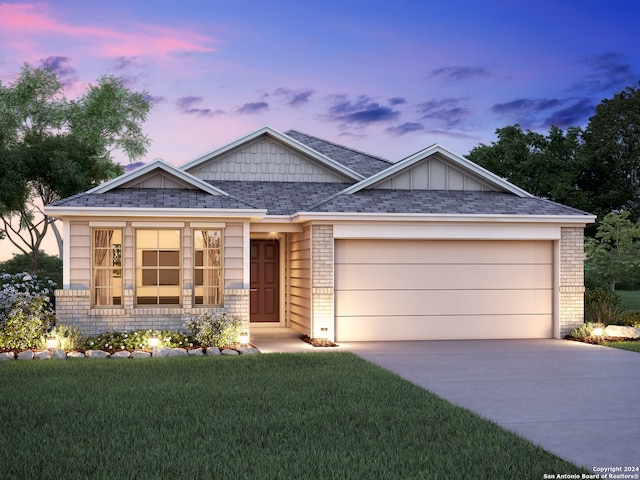 view of front of property with a yard and a garage