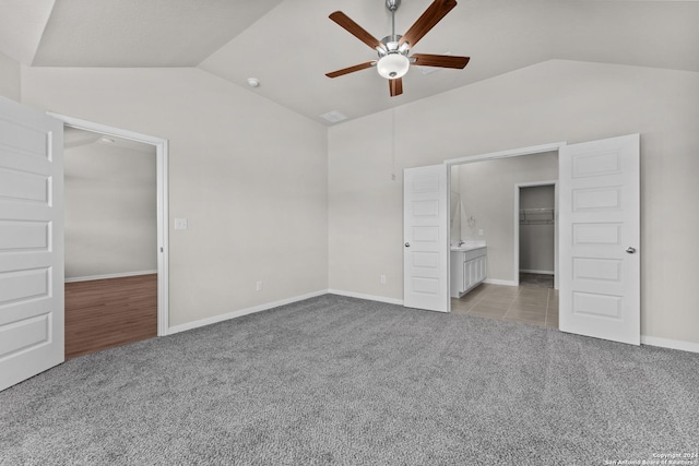 unfurnished bedroom with ceiling fan, light colored carpet, lofted ceiling, and a closet