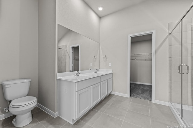 bathroom with tile patterned floors, vanity, toilet, and a shower with shower door