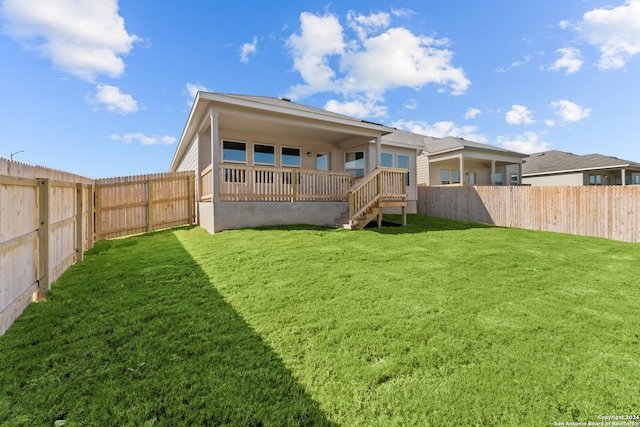 rear view of property featuring a lawn