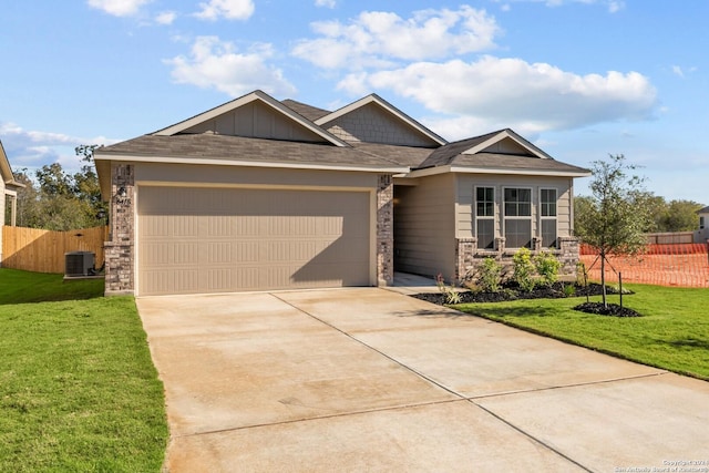 view of front facade with central air condition unit, a front yard, and a garage