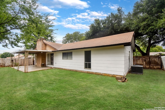 rear view of property featuring central air condition unit, a patio area, and a yard