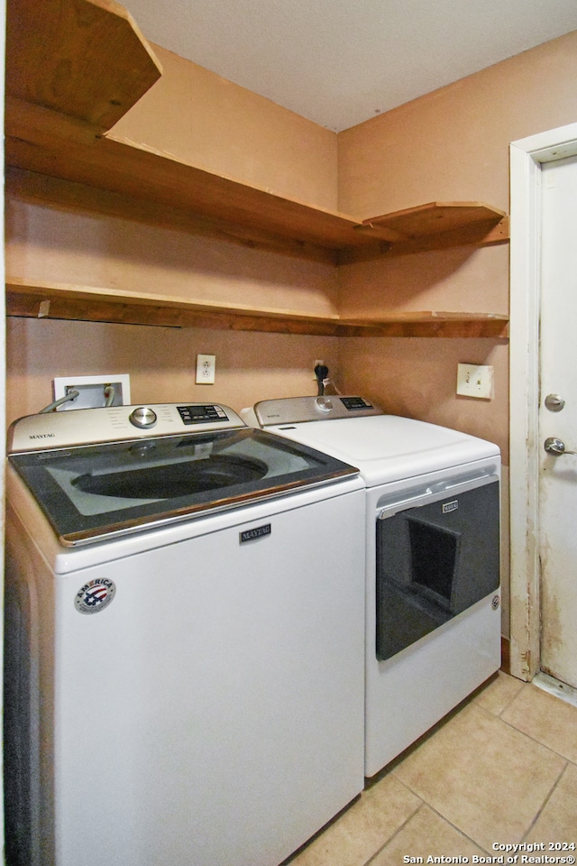 washroom with independent washer and dryer and light tile patterned floors