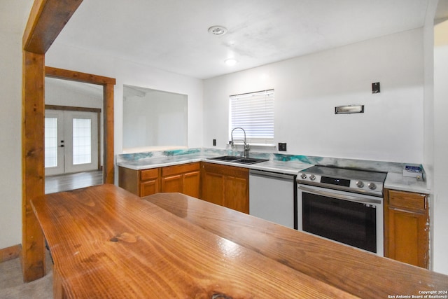 kitchen with appliances with stainless steel finishes, french doors, and sink