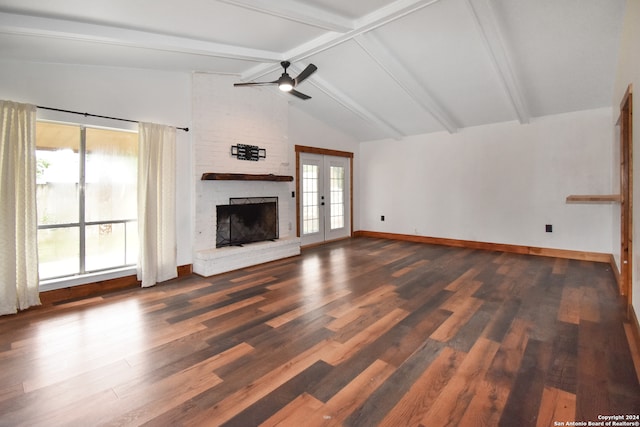 unfurnished living room featuring hardwood / wood-style flooring, vaulted ceiling with beams, brick wall, and a wealth of natural light