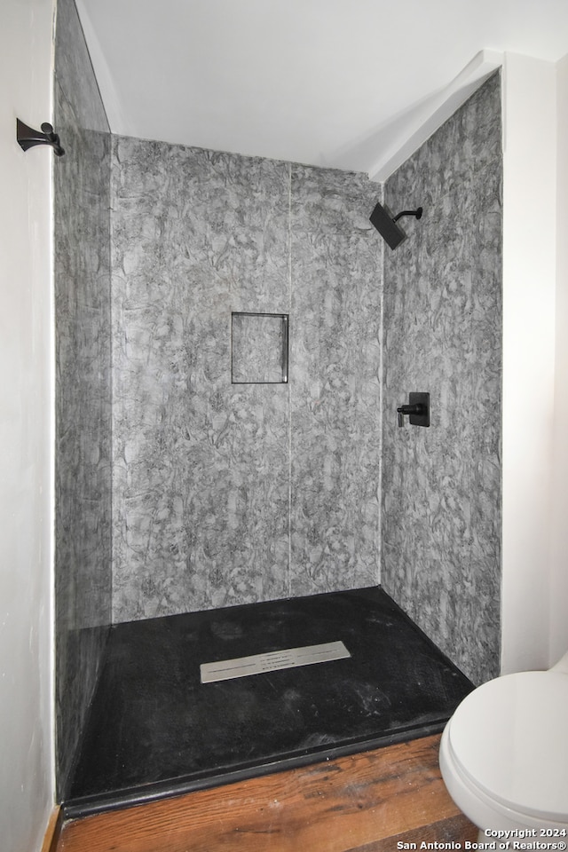 bathroom featuring toilet and a tile shower