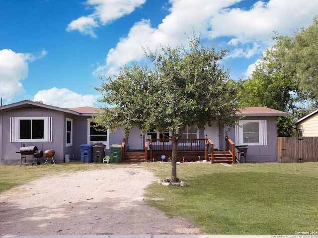 view of front of home with a wooden deck and a front yard