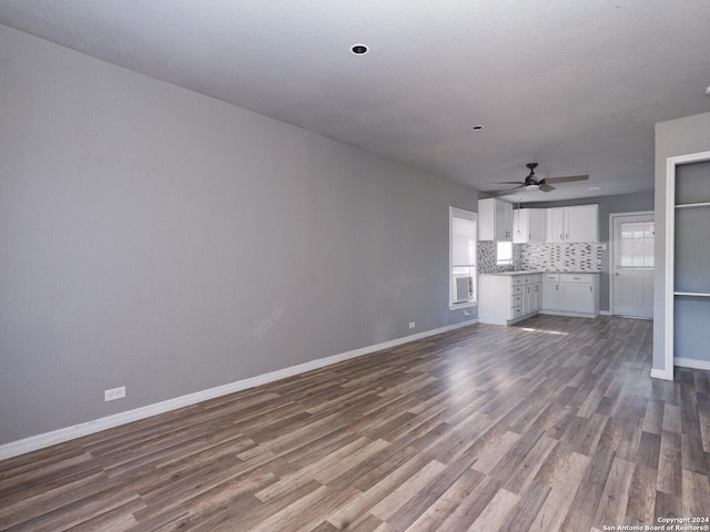 unfurnished living room with ceiling fan and dark hardwood / wood-style flooring