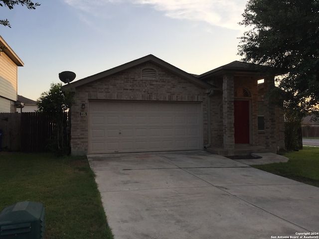 view of front of house with a garage and a lawn