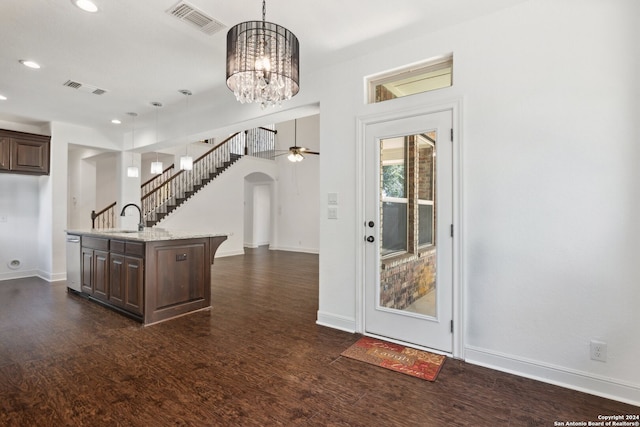 kitchen with an island with sink, dark wood-type flooring, hanging light fixtures, and sink