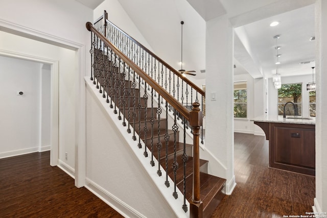 stairs with wood-type flooring, sink, and ceiling fan