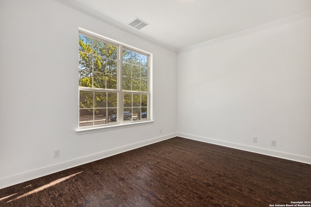 empty room featuring ornamental molding, plenty of natural light, and wood-type flooring