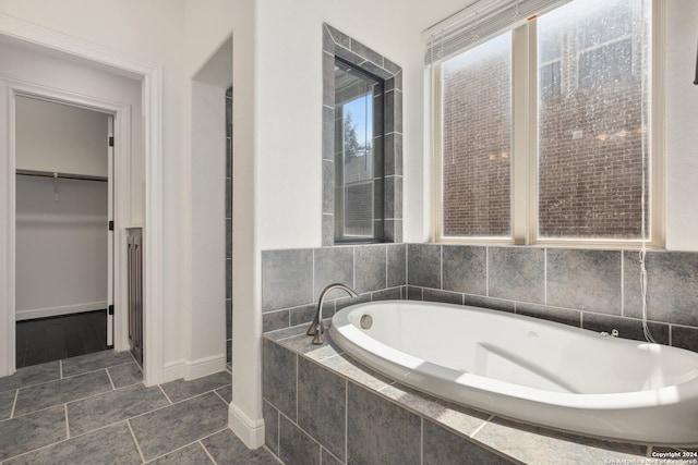 bathroom featuring tiled bath and tile patterned floors